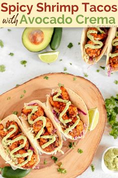 three shrimp tacos with avocado and cilantro sauce on a wooden platter