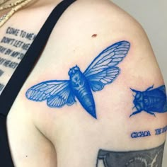 a woman's shoulder with two blue bugs on it and the words cica in front of her