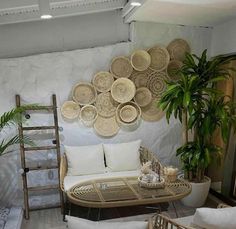 a living room with wicker furniture and plants on the wall, along with a ladder