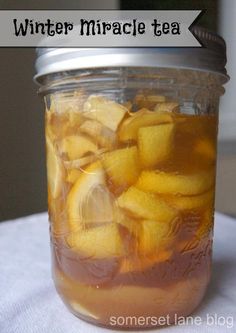 a glass jar filled with sliced lemons on top of a table