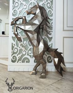 a metal horse sculpture sitting on top of a tile floor next to a white wall