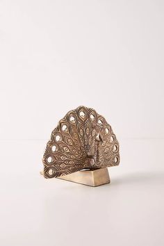 an antique brass peacock ring on a white background