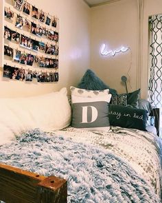 a bed with pillows and pictures on the wall