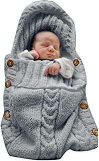 a baby wrapped in a blanket with buttons on the bottom and hood, is laying down