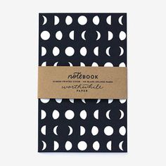 a notebook with black and white polka dots on the cover, sitting on top of a table