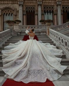 a woman in a wedding dress standing on some stairs