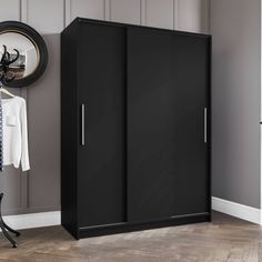 a black wardrobe with two doors and a mirror on the wall next to a coat rack