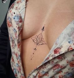 a woman's breast with a flower tattoo on her left side shoulder and chest