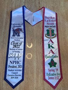 two neck ties with the names of each school and year on them, sitting on a table