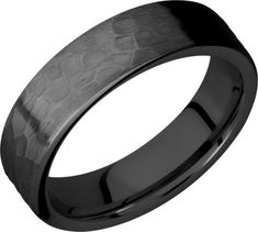 black ceramic wedding ring with an intricate design inlayed into the center, on a white background