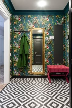 a bathroom with a green coat hanging on the wall and a red bench in front of it