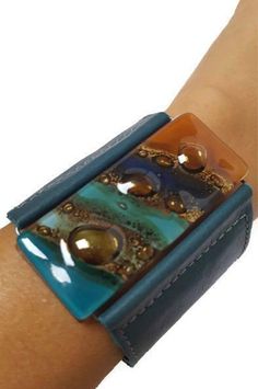 Amazing Handmade Leather cuff. Wide Leather Cuff. Dark green Leather Bracelet. Recycled glass Bracelet. Terracotta, teal brown, and blue cuff. All the leather used is reclaimed!! The leather is cut, glued, and stitched for durability. The band is real leather 2'' wide. The cuff is adjustable with 2 double snaps at approx 7'' and 7.6''. Although One size fits most this bracelet is on the bigger side. The glass bead is made of 3 layers of recycled fused glass. The glass is cut colored and painted. Fused Glass Jewelry, Brown And Blue, Glass Bracelet, Macrame Patterns, Leather Cuffs, 3 Layers, Recycled Glass, Leather Jewelry, Green Leather