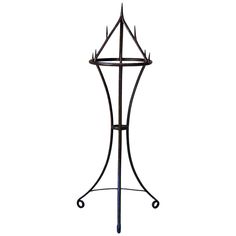 a tall metal stand with two birds on it's top and one bird sitting on the bottom