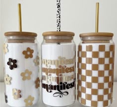 three jars with gold and white designs on them