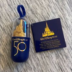 a disney world 50 year anniversary ornament next to a passport