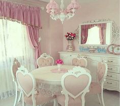 a pink and white dining room with hearts on the table