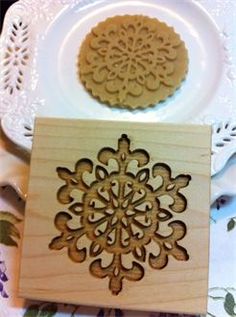 two wooden coasters sitting on top of a white plate next to a flower design