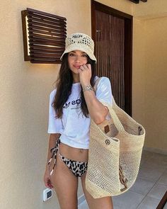 a young woman is standing outside with her hand on her face and holding a purse