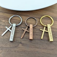 three different key chains with the names of jesus christ and two crosses on each one