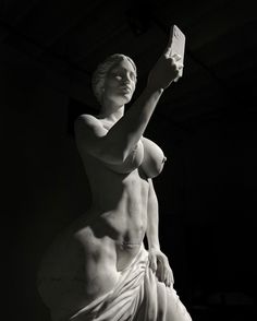 black and white photograph of a statue holding a book