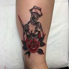 a tattoo on the leg of a person with a knife and rose in front of them