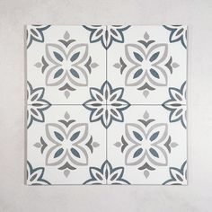 a white and grey tile with flowers on it