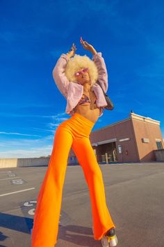 a woman in an orange outfit is dancing