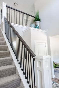 there is a plant on top of the banister in this house's entryway