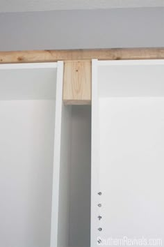 an open closet door is shown with the bottom panel missing from the wall and wood