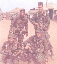 four soldiers posing for a photo in the desert