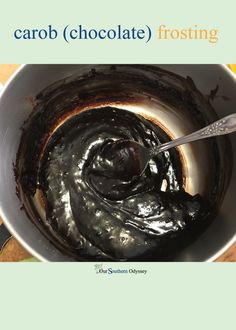 a white bowl filled with chocolate frosting on top of a wooden table