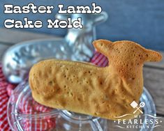 an easter lamb cake mold sitting on top of a glass plate next to a red and white checkered napkin