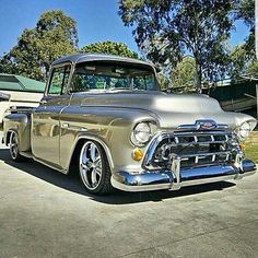 an old silver truck parked in a driveway