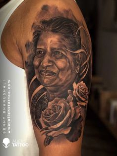 a man with a tattoo on his arm has a portrait of a woman and roses