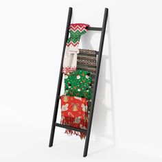 a ladder with blankets hanging from it's sides in front of a white wall