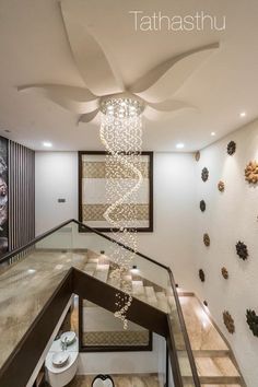 an elegant staircase with chandelier and decorative wall hangings