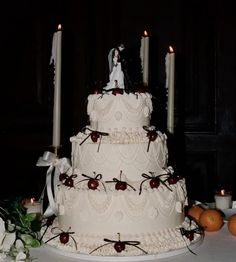 a wedding cake with candles and fruit on the table