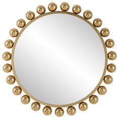 a round mirror with gold balls around it