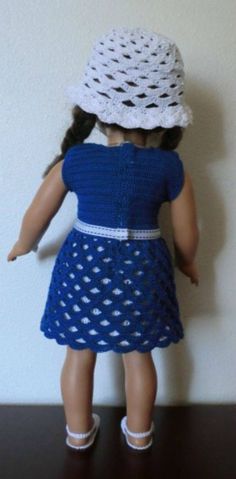 the doll is wearing a blue dress and white hat