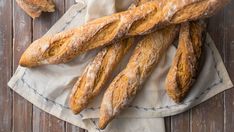 several loaves of bread sitting on top of a napkin next to a baguette