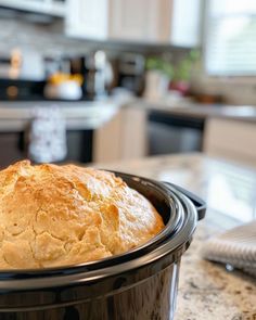 a loaf of bread in a crock pot on a kitchen counter with the lid open