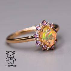 Mexican Fire Opal Amethyst Diamond Engagement Halo Ring 18K Yellow Gold. Free Domestic USPS First Class Shipping! Free One Year Limited Warranty! Free Gift Bag or Box with every order! Opal—the queen of gemstones, is one of the most beautiful and rarest gemstones on earth. Every piece of opals has its colors and patterns, which is perfect for designers to create unique engagement rings for someone extra special. Our jewelry uses 100% Natural & Ethical opal stones (NO synthetics or imitations). - Fire Opal Wedding Ring, Opal Sapphire Ring, Gold Opal Rings, Rarest Gemstones, Opal And Sapphire Ring, Fire Opal Engagement Ring, Opal Promise Ring, Mexican Fire Opal Ring, Dream Rings