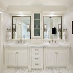 a large bathroom with double sinks and two mirrors on the wall next to each other