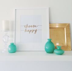 there are three vases on the shelf next to a framed photograph and candle holder