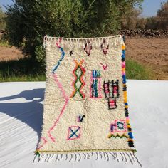 a white rug with multicolored designs on it