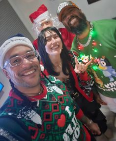 three people wearing ugly christmas sweaters posing for the camera