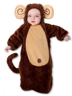 a baby in a monkey costume laying on the ground with its arms out and eyes closed