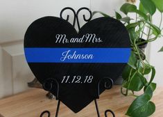 a black heart shaped sign with a blue stripe on the front and back that says mr and mrs johnson