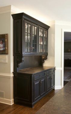 a kitchen with black cabinets and wood floors