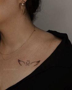 a woman's chest with a small tattoo on the left side of her neck